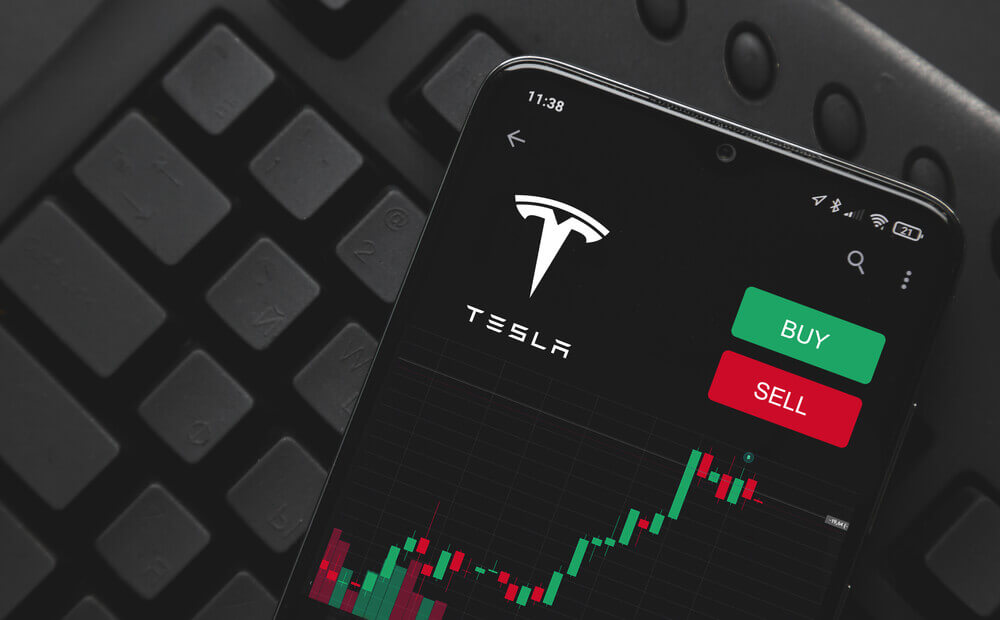 Logo Tesla on screen smartphone. rise and fall of Tesla shares on the stock exchange